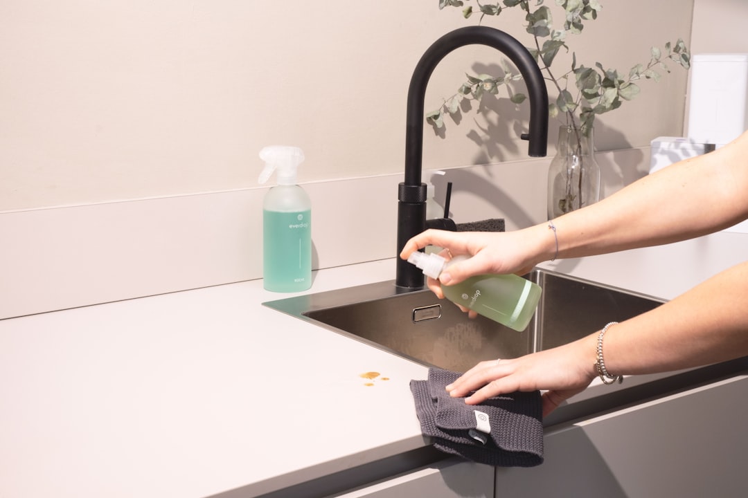 heros-img a-woman-is-cleaning-a-kitchen-sink-with-a-rag-sqomdoqb3ws